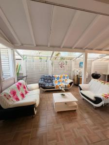 a living room with couches and a table at Villa Lumineuse in Le Lamentin