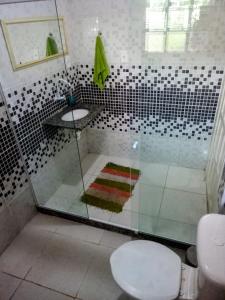 a bathroom with a shower with a toilet and a sink at Rancho Magic in Cabo Frio +42 photos