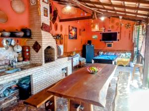 a kitchen with orange walls and a wooden table at Rancho Magic in Cabo Frio