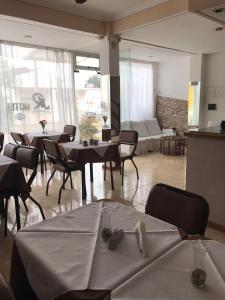 a room with tables and chairs and a living room at Hotel JR in Mar del Tuyú