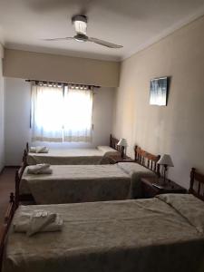 a room with three beds and a window at Hotel JR in Mar del Tuyú