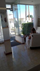 a woman sitting on a bed in a room with a mirror at Hotel JR in Mar del Tuyú