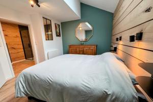 ein Schlafzimmer mit einem großen weißen Bett und einem Spiegel in der Unterkunft Le BrasÔvert in Bras