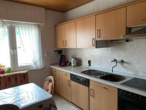 a kitchen with wooden cabinets and a sink and a table at Seppel's Häuschen in Bad Orb