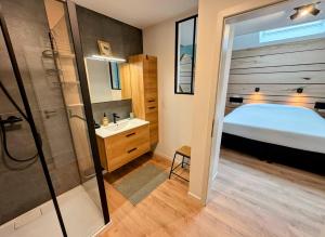 ein Badezimmer mit Bett, Dusche und Waschbecken in der Unterkunft Le BrasÔvert in Bras