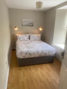 a small bedroom with a bed with two pillows at Chambers Cottage in Drumellihy