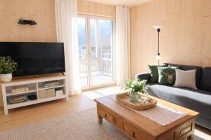 a living room with a couch and a tv at ChiemseeRefugium - Ferienwohnung Berg in Bernau am Chiemsee