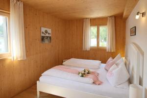 a bedroom with a white bed with flowers on it at ChiemseeRefugium - Ferienwohnung Berg in Bernau am Chiemsee