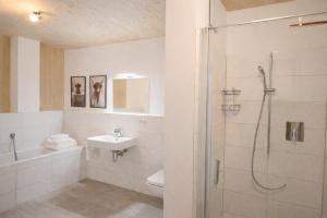 a white bathroom with a shower and a sink at ChiemseeRefugium - Ferienwohnung Berg in Bernau am Chiemsee +17 photos