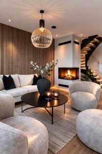 a living room with a couch and a fireplace at OceanView Karmoy Jacuzzi, Sauna & Sea Views in Karmøy
