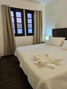 ein Schlafzimmer mit einem Bett, auf dem weiße Handtücher liegen in der Unterkunft Wanderlust Hostel B & B in Santiago