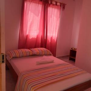 a bedroom with a bed with a pink curtain at Villa del coco Hospedajes in Arboletes +6 photos
