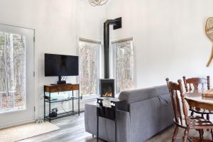 a living room with a couch and a fireplace at Maison Eadda in Adstock