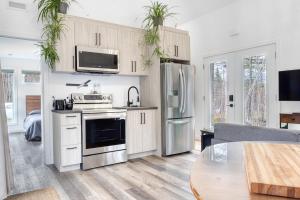 a kitchen with white cabinets and a stainless steel refrigerator at Maison Eadda in Adstock