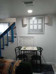 a table and chairs in a room with a staircase at "Cozy Basement Retreat Just 40 Minutes to NYC!" in Irvington