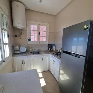 a kitchen with white cabinets and a refrigerator at Mina House in Chefchaouen