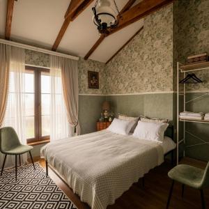 a bedroom with a bed and two chairs and a window at Villa Khodasheni in Kʼvemo Khodasheni