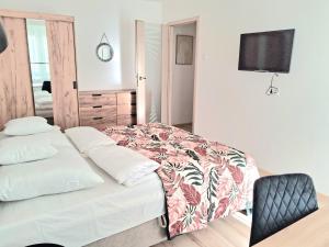 a bedroom with a bed and a tv on the wall at Apartament Bursztynowy in Ustka