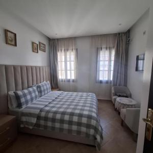 a bedroom with a bed and a couch and windows at Mina House in Chefchaouen