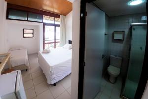 a small bathroom with a bed and a toilet at Pousada Maraca Beach in Porto De Galinhas +76 photos