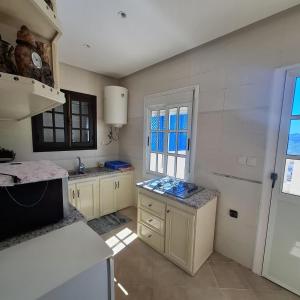 a kitchen with white cabinets and a counter top at Mina House in Chefchaouen +12 photos