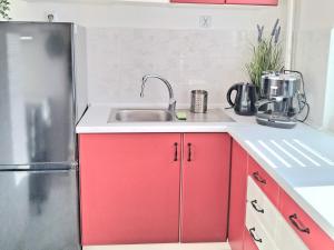 a kitchen with a sink and a refrigerator at Apartament Bursztynowy in Ustka