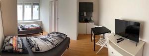a living room with a couch and a flat screen tv at Gästehaus JaWo in Neuruppersdorf