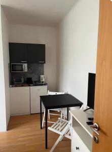 a small kitchen with a black table and a desk at Gästehaus JaWo in Neuruppersdorf
