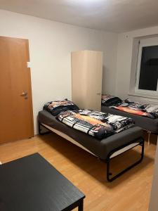 two beds sitting in a room with a door at Gästehaus JaWo in Neuruppersdorf