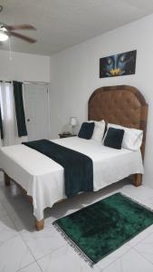 a bedroom with a large bed with a green rug at Holiday festivity in St Mary