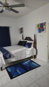 a bedroom with a bed with blue pillows and a ceiling at Holiday festivity in St Mary +3 photos