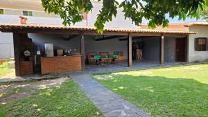 a house with a patio with a table and chairs at Casa da Passagem in Cabo Frio