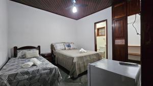 a small room with two beds and a table at Casa da Passagem in Cabo Frio