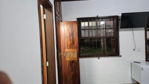 a room with a wooden door and a window at Casa da Passagem in Cabo Frio +8 photos