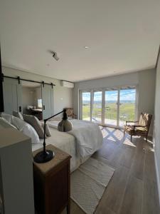 a bedroom with a bed and a table with a lamp at Buenos Vientos Casa de Campo in Maldonado