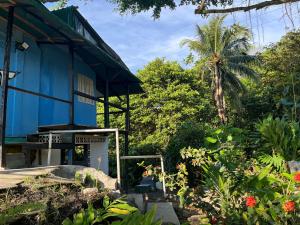 a blue house with a garden in front of it at Hostal el peñón in Buenaventura