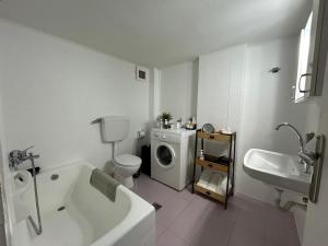 a bathroom with a tub sink and a washing machine at MG elounda apt in Elounda +37 photos