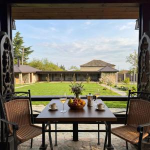 a table with a bowl of fruit and wine glasses at Villa Khodasheni in Kʼvemo Khodasheni