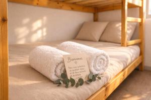 two bunk beds with towels and a sign on them at L Echappee Jardin prive proche plage Sainte Cecile in Camiers