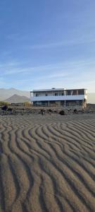 a building in the middle of a desert with a desert at Kasa surf in Porto Novo