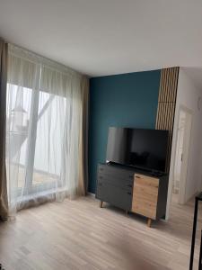 a living room with a flat screen tv on a dresser at Leo Stay in Leopoldsdorf