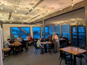 a group of people sitting at tables in a restaurant at Dildo Boathouse Inn in Dildo