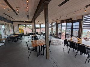 a dining room with tables and chairs and windows at Dildo Boathouse Inn in Dildo +16 photos