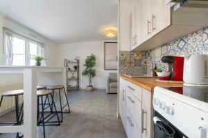 a kitchen with white cabinets and a counter top at T2 cocooning proche Paris et Disney in Lagny