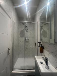 a white bathroom with a shower and a sink at Sauna flat Central Brighton in Brighton & Hove