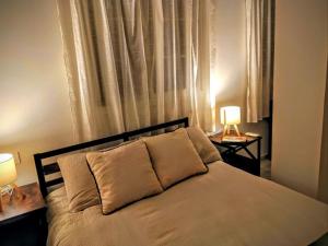a bedroom with a bed with two lamps on tables at Forrent malaga in Málaga +13 photos