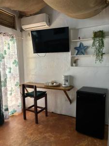 a room with a table and a television on a wall at Hotel Restaurant Wuarao - Antiguo Club Rolling Stones in Boca Chica