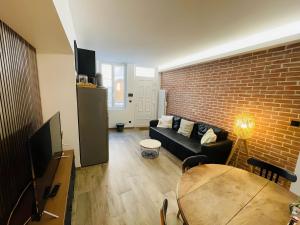 a living room with a couch and a brick wall at Le Charmant Bailla Science-Po in Reims