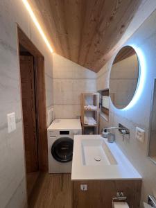 a small bathroom with a washing machine and a sink at La Grangette in Grimentz
