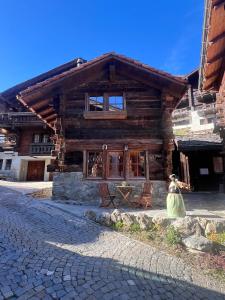 a log cabin with two chairs in front of it at La Grangette in Grimentz